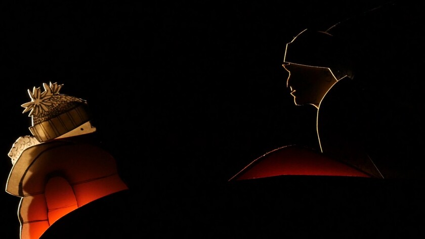 The Ghost of Christmas Past (right) visits Scrooge (left) in Manual Cinema’s “Christmas Carol.”
