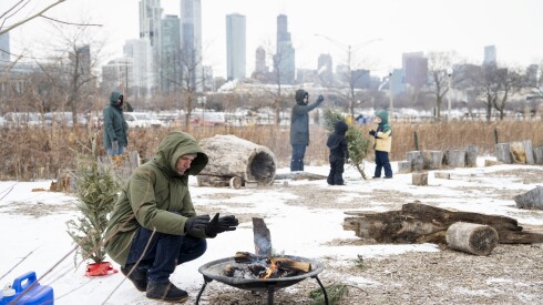 A man warms up near an outdoor fire during Polar Adventure Days at Northerly Island, Saturday, Jan. 24, 2026.