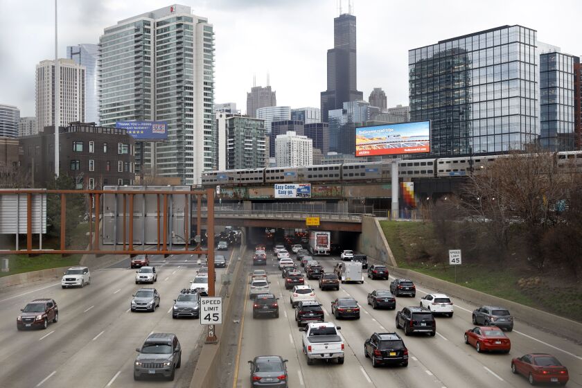 In this March 31, 2021,photo, traffic flows along Interstate 90 highway as a Metra suburban commuter train moves along an elevated track in Chicago. Congress has created a new requirement for automakers: find a high-tech way to keep drunken people from driving cars. It’s one of the mandates along with a burst of new spending aimed at improving auto safety amid escalating road fatalities in the $1 trillion infrastructure package that President Joe Biden is expected to sign soon.