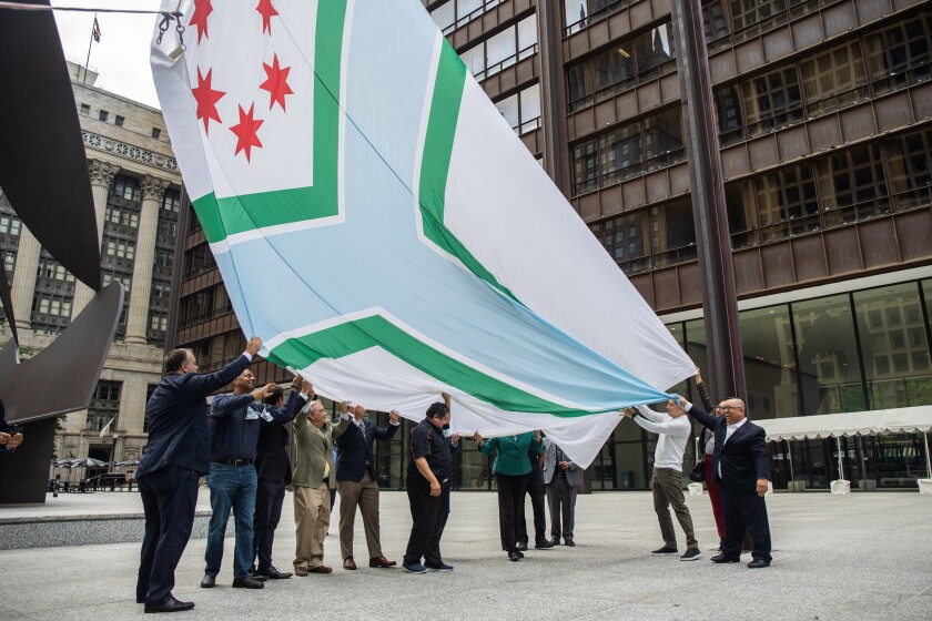 Должностные лица и дизайнер Дрю Даффи помогают поднять новый флаг округа Кук во время открытия нового флага на Дейли Плаза в Лупе в субботу, 24 сентября 2022 года. Новый флаг округа Кук был разработан Дрю Даффи, учеником средней школы, который под руководством своего наставника Мартина Бурсиаги. | Пэт Набонг / Sun-Times