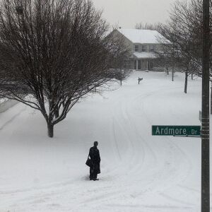 A commuter waits for a PACE bus Friday morning in Naperville. Schools in District 204 (Naperville/Aurora) were closed.
