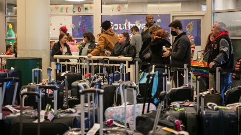 People looking for their lost luggage line up outside Southwest Airlines’ office near the baggage carousel at Midway Airport, December 27, 2022, after Southwest Airlines flights were cancelled and delayed during winter storm Elliott.