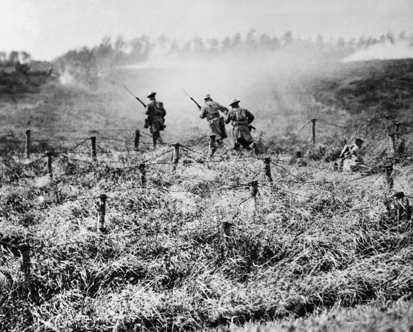 U.S. troops of the 107th Regiment Infantry, 27th Division, advance through a barbed wire entanglement near Beauqueanes, Somme, France in September 1918. | Associated Press/U.S. Army Signal Corps