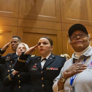 Women veterans of every branch of the U.S. military, salute as the honor guard file into an auditorium at the Pritzker Military Museum and Library for the announcement of the first all women honor flight to Washington D.C. later this year, Tuesday, Feb. 25, 2020.