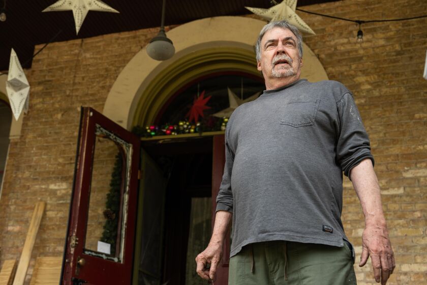 Jim Bowers, the owner of the Seth P. Warner House in the 600 block of North Central Avenue in Austin, stands on his porch after the house caught fire early Thursday, June 15. The home, which was designated landmark status in 2022, is the oldest home in the Austin neighborhood, according to the city.