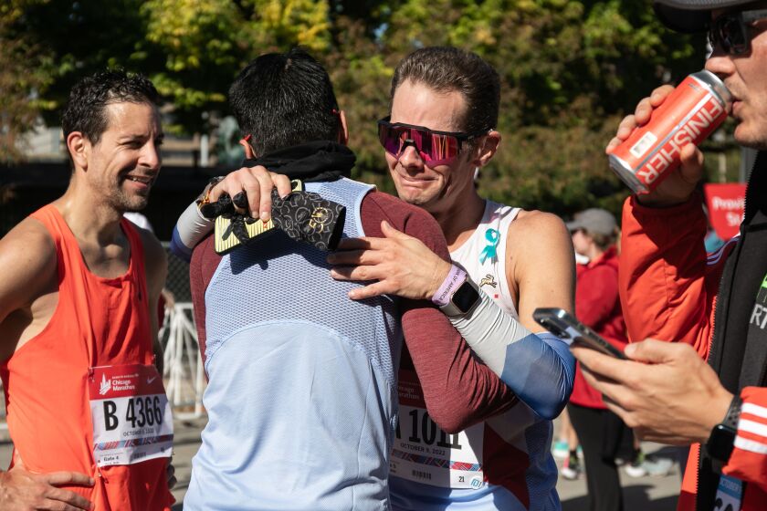 Thomas Eller from Essen (center right) after crossing the finish line along South Columbus Drive.