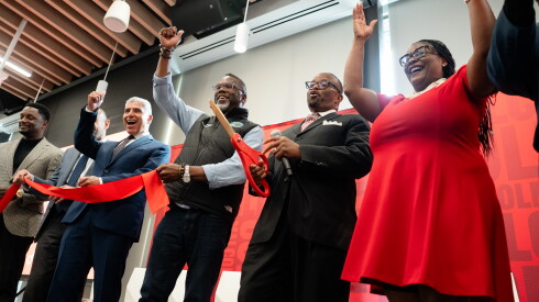 City College of Chicago Chancellor Juan Salgado (in blue), Chicago Mayor Brandon Johnson and Malcolm X College President David Sanders (in black suit) cheer after cutting a ribbon for the newly renovated community center