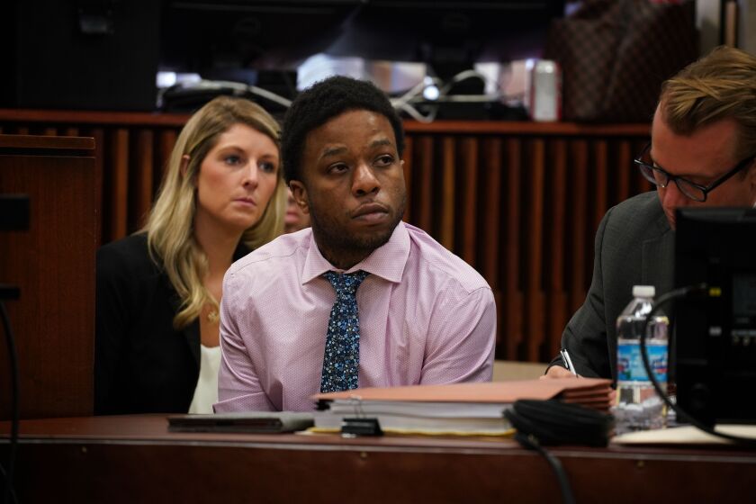 Corey Morgan, on trial for the murder of Tyshawn Lee, sits beside his lawyers Tuesday during opening statements at the Leighton Criminal Court Building.