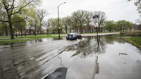 A car passes through flood water near West Warren Boulevard and West Washington Boulevard in Garfield Park on Wednesday.