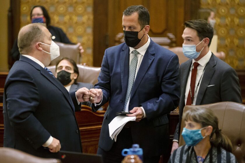 State Sen. Michael Hastings, D-Tinley Park, center, is congratulated after the omnibus energy bill passes the Senate in the early morning hours Wednesday.