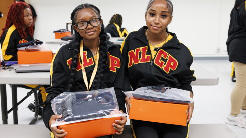Milan and Emily both sit with their new cleats and gear at North Lawndale Phoenix flag football team