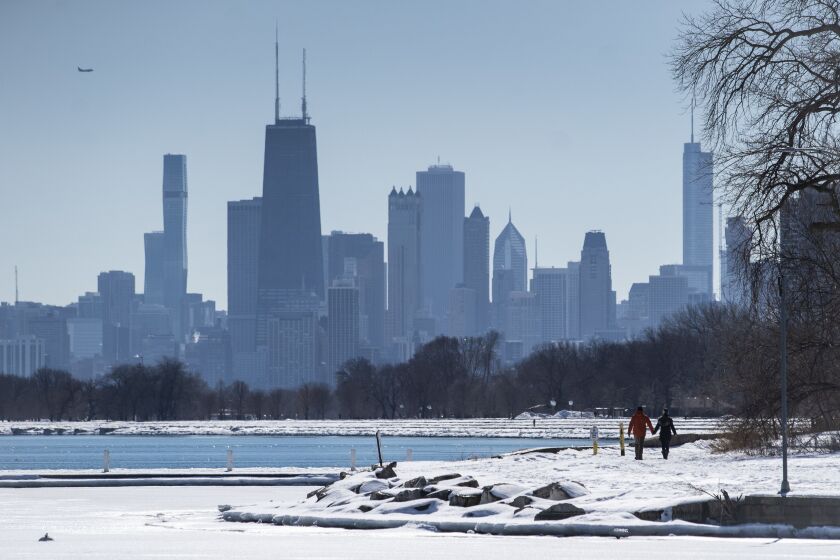 People walk along the lakefront Tuesday near a portion West Montrose Avenue east of Lake Shore Drive that had been closed since March amid fears of the coronavirus pandemic. The Chicago Park District announced plans Tuesday to gradually reopen the city’s lakefront, playgrounds and indoor swimming pools in response to sustained declines in COVID-19 positivity rates and cases.