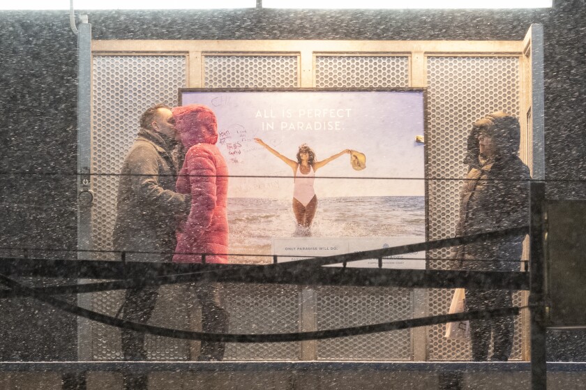 A couple kisses while waiting for a southbound Red Line train at the Thorndale stop in Edgewater as snow falls across the Chicago area on Valentine's Day, Feb. 14.