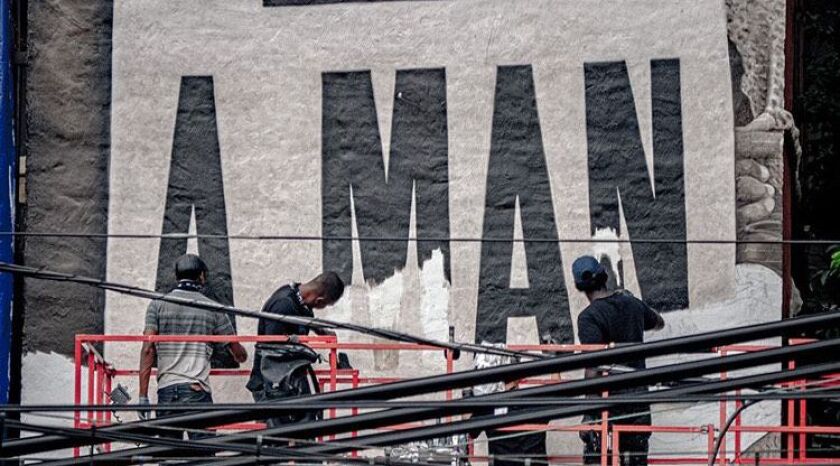 Jared Diaz (from left), Darius Dennis, Robin Alcantara (hidden) and Ephraim Gebre work on the lettering of the “I AM A MAN” mural in Wicker Park.