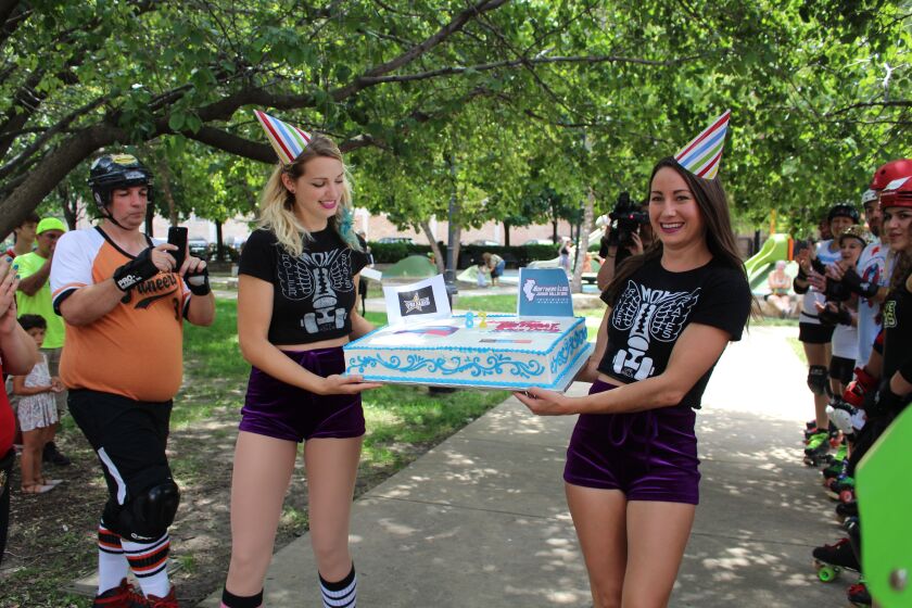 Karli Craig and Katie Baird skate out with a birthday cake at a roller derby celebration in Coliseum Park in the South Loop neighborhood. | Emily Moon/Sun-Times
