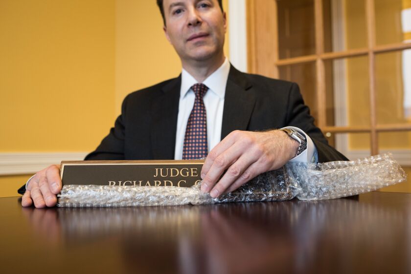 Former Cook County Judge Richard Cooke holds his old judge nameplate.