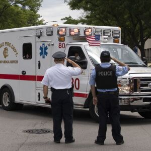 Officers salute outside the Cook County medical examiner’s office Tuesday as an ambulance passes carrying the body Deputy Chief Dion Boyd, who was found dead in his office Tuesday morning, July 28, 2020 of an apparent self-inflicted gunshot wound.