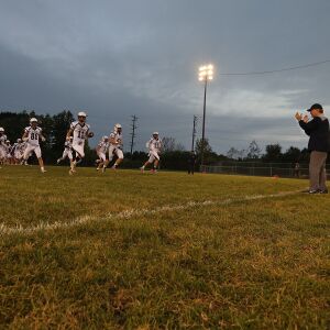 Lisle’s coach Paul Parpet leads the Lions onto the field. | Allen Cunningham / for Chicago Sun-Times