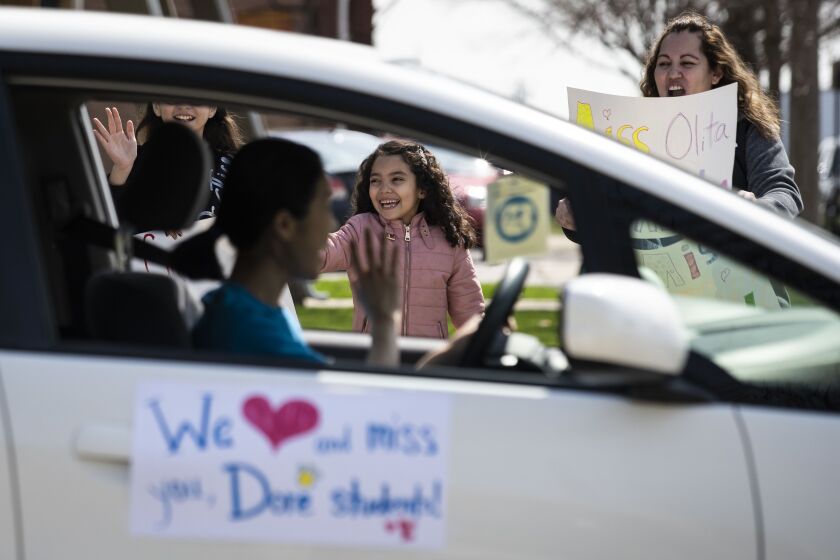 While the school building is closed amid fears of the coronavirus pandemic, teachers and other staff at John C. Dore Elementary School parade around the neighborhood waving to families and children on the Southwest Side, Thursday afternoon, April 2, 2020.