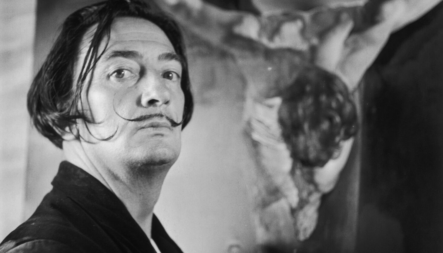 Fine Art in Rap Music: Salvador Dali stands beside his painting entitled “Christ of St John On The Cross” at his studio at Port Lligat on Nov. 17, 1951, near Cadaques, Spain. Getty Images