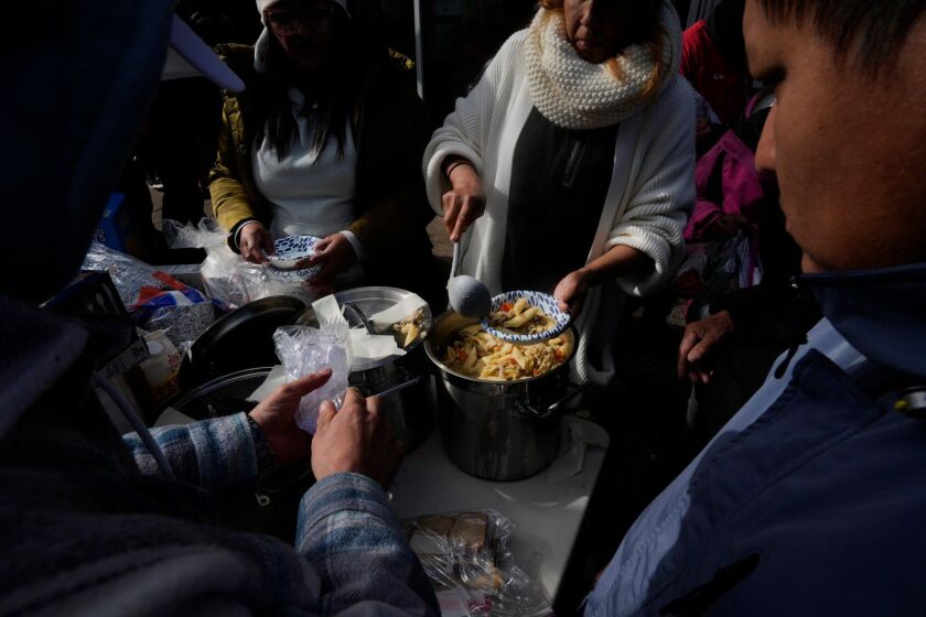 Migrants are serve a meal near a North Side police station where they’ve been living in a small tent community in Chicago. For many migrants, the basic needs of food and shelter have trumped getting help for the trauma they’ve endured.
