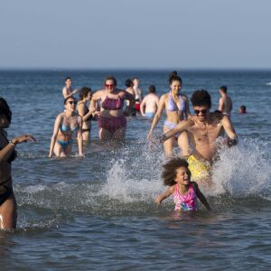 A group of people run and splash in Lake Michigan at Montrose Beach, Tuesday, June 14, 2022. As Chicago experiences its hottest day of the year.
