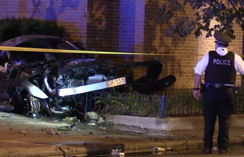 A Chicago police officer surveys the wreckage of a fiery crash on the Ontario Street feeder ramp early Monday. | Network Video Productions