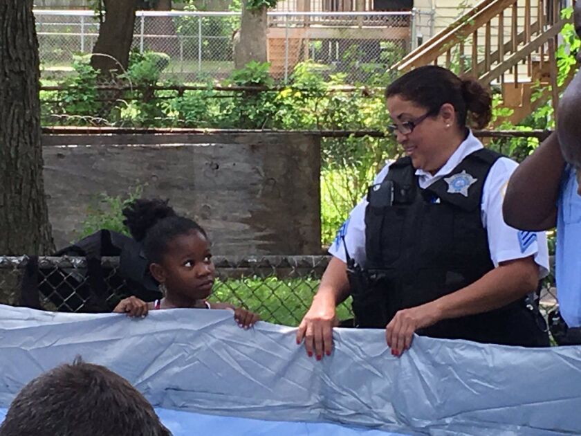 Tacarra Morgan looks at Sgt. Elise Padilla, who spearheaded Thursday’s Operation Backyard Pool, as they hold up the edge of the pool. | Maudlyne Ihejirika/Sun-Times