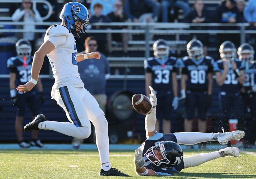 Lake Zurich's Tyler Vuckovic, left, attempts a punt that Nazareth's Henry Sakalas blocks in the fourth quarter as the Roadrunners come from behind to win 24-21 on Nov. 15 in La Grange Park.