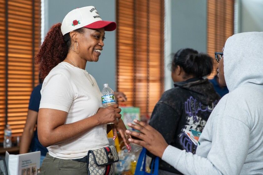 Doula Zetanefert Zipewtu helps a guest at the Black Maternal Health Week Baby Shower at the Garfield Park Fieldhouse on Saturday.