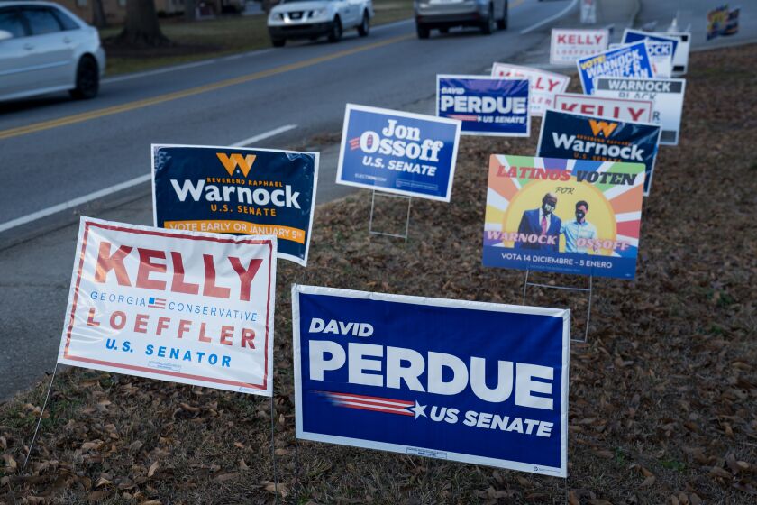 Signs line a road at a Gwinnett County voting location Tuesday in Atlanta, Georgia.
