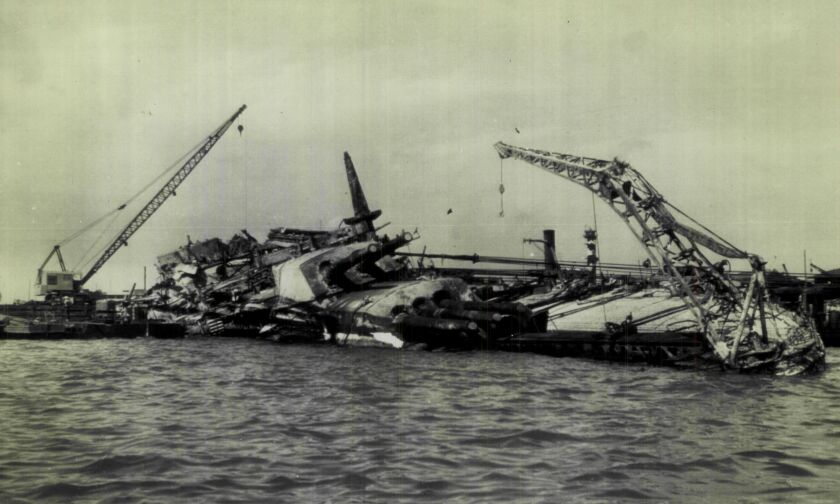 In 1943, cranes were used to lift deck equipment from the USS Oklahoma, and cables (right center) pulled the craft into an upright position in Pearl Harbor during salvage operations. | Associated Press