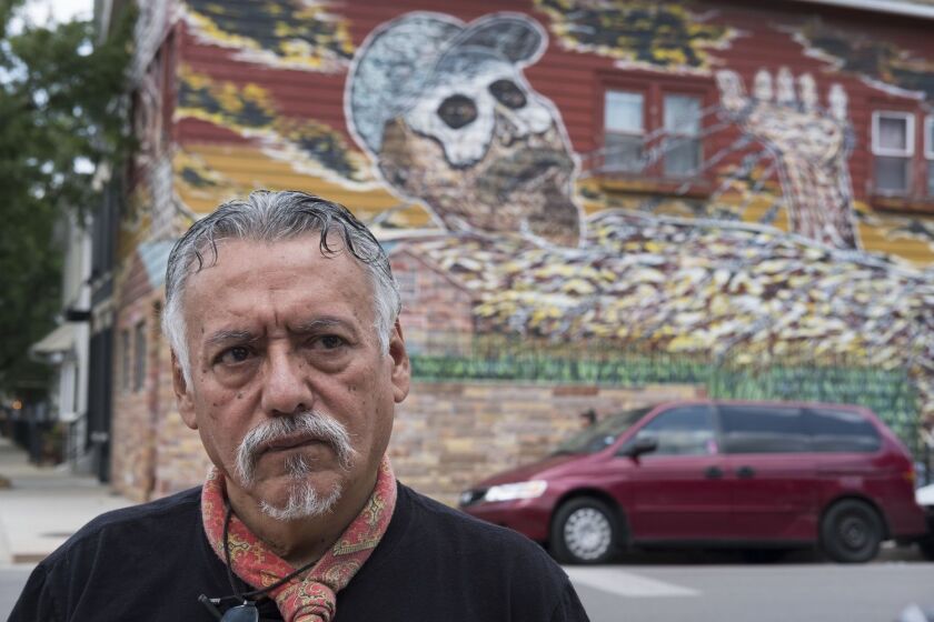 Hector Duarte and the mural that adorns his home in Pilsen.