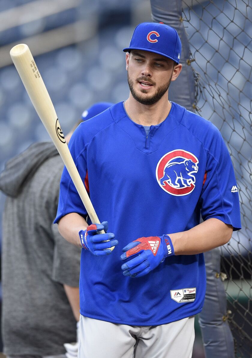 Kris Bryant checks over his bat during batting practice.