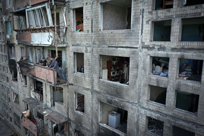 Workers begin to remove debris from a Kyiv apartment block the was hit by a Russian missile in March.