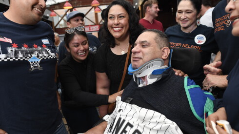 Chicago Police Officer Nelson Crespo is greeted by family and friends at a fundraiser in Wrigleyville on Friday.