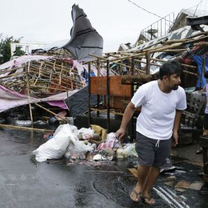 A resident walks past damaged stalls at a public market as Typhoon Mangkhut barreled across Tuguegarao city in Cagayan province, northeastern Philippines on Saturday, Sept. 15, 2018. The typhoon slammed into the Philippines northeastern coast early Saturd