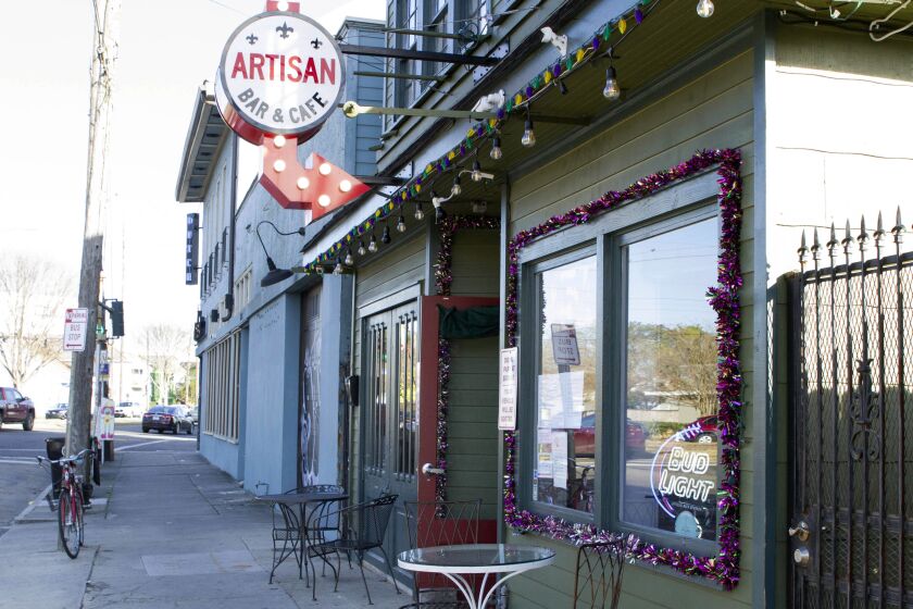 A bike sits outside Artisan Bar and Cafe on St. Claude Avenue in New Orleans. The toll of this year’s toned-down Mardi Gras is evident on this off-the-beaten-track stretch that has become a destination in recent years.