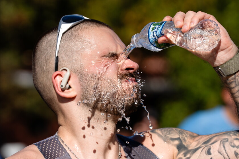 A runner pours water on his face as he approaches Mile 22 in Bronzeville during the Bank of America Chicago Marathon on Sunday.