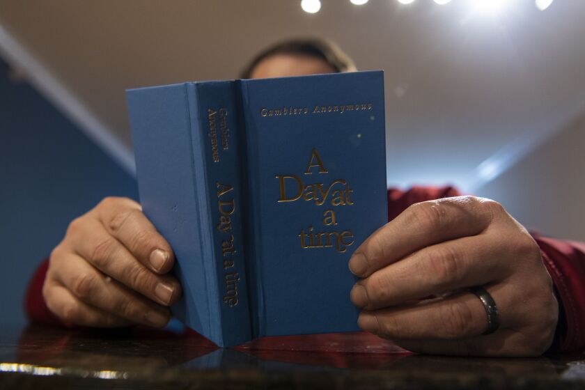 A recovering sports gambling addict reads his favorite passages from ‘A Day at a Time’ a book by Gamblers Anonymous last month.