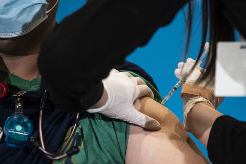 Nurse Shannon Lesch administers a COVID-19 vaccination.