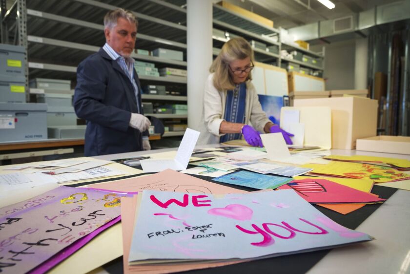 Jan Ramirez (right), chief curator at the 9/11 Memorial & Museum, sifts through a collection of condolence cards for a victim of the Sept. 11, 2001, attacks that were donated to the museum’s archive. The museum has collected 22,000 personal artifacts to help tell the stories of those who died and those who were lucky to survive.