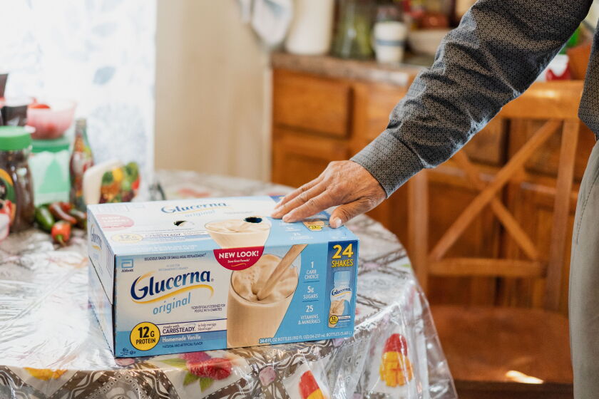 Felix, 71, who receives $500 a month from the City of Chicago’s Resilient Communities Pilot program and uses some of the money to pay for groceries, shows a box of Glucerna, which his wife drinks, in their kitchen in the Pilsen neighborhood.