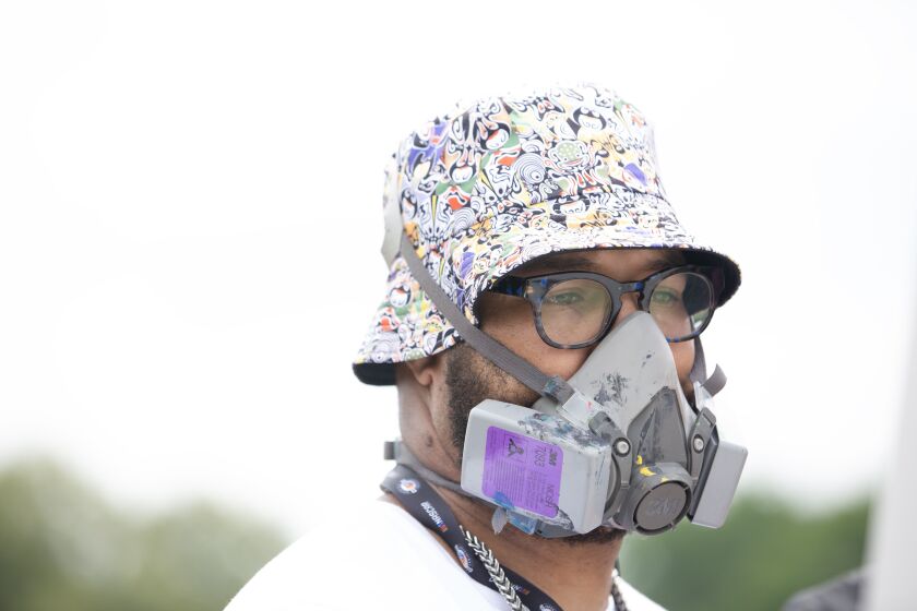 Blake Lenoir wears a mask while painting at the NASCAR Chicago Street Race on Saturday, July 1, 2023 in Chicago.