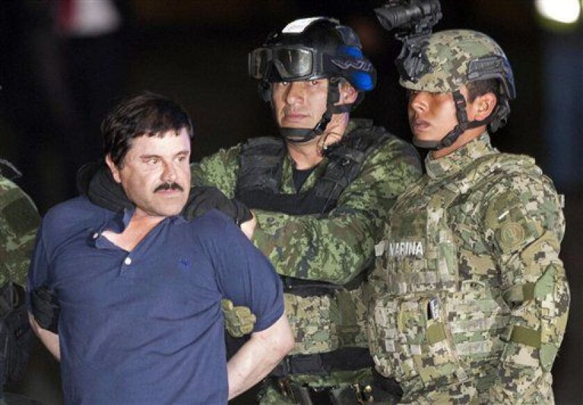 Joaquin “El Chapo” Guzman is made to face the press as he is escorted to a helicopter in handcuffs by Mexican soldiers and marines. | AP file photo