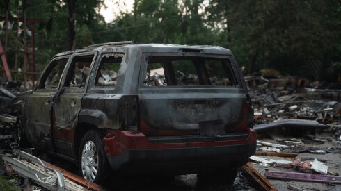 The husk of a Jeep sits near the remains of a home in Portage, Indiana on Wednesday, Aug. 12, 2025.. The home was destroyed in an explosion Tuesday as storms hit the area. The cause of the explosion has not been determined.
