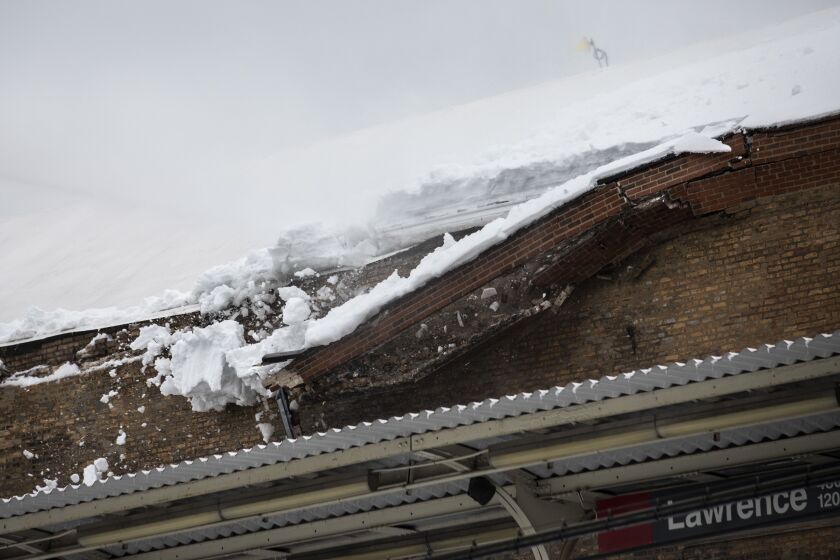 Chicago Fire Department firefighters spray water on the roof of the Aragon Ballroom to knock loose at least a foot snow that had accumulated and damaged a brick wall on the North Side building Tuesday.