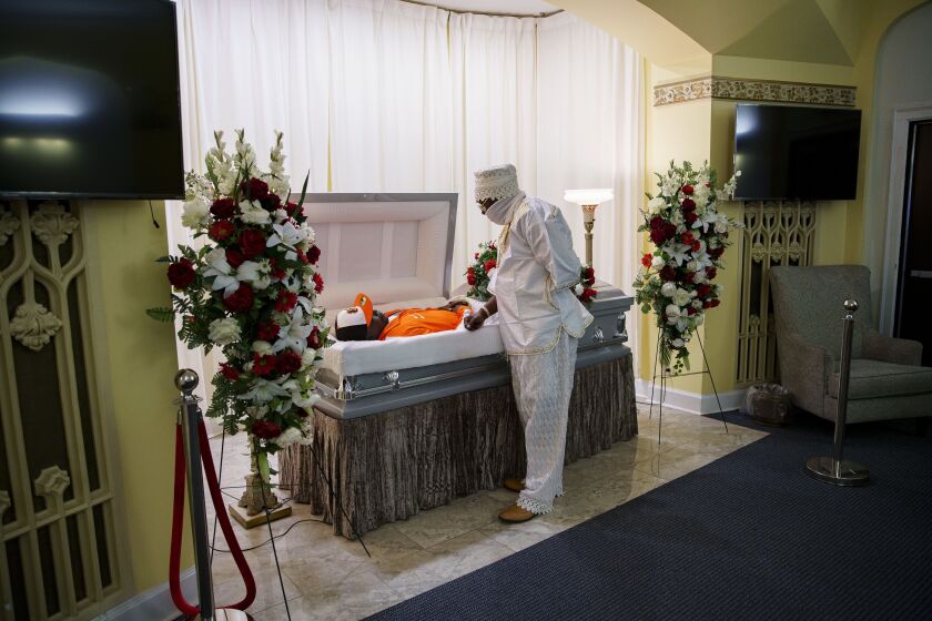 Olumide Olupitan looks down on his brother, Oyedele Oluptian, at his visitation at Sacred Memories Funeral Home in South Shore, Saturday afternoon, Sept. 5, 2020. Chicago police said Oyedele Oluptian, 42, was found unresponsive with a gunshot wound to his head on Aug. 18 in the 9300 block of South Halsted Street in the Washington Heights neighborhood on the South Side.