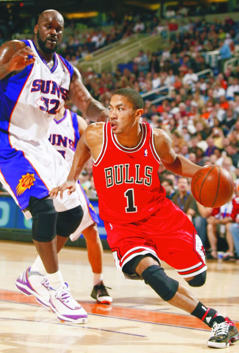 Derrick Rose drives past Phoenix Suns Shaquille O’Neal during the second quarter of an NBA basketball game on Jan. 31, 2009, in Phoenix. | Rick Scuteri/Associated Press