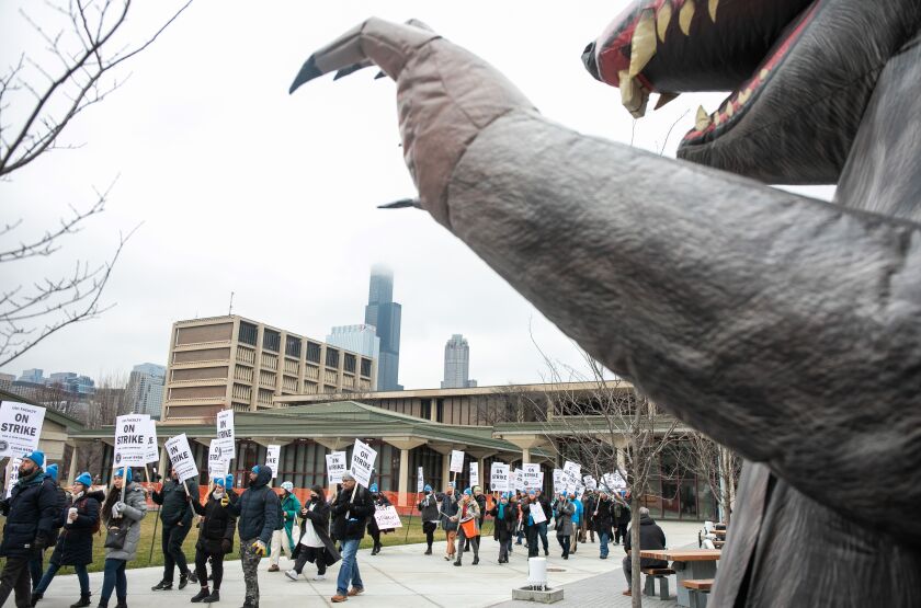 Faculty and their supporters chant as Scabby the Rat is seen in the foreground during a strike at the University of Illinois Chicago in the Little Italy neighborhood, Tuesday, Jan. 17, 2023.